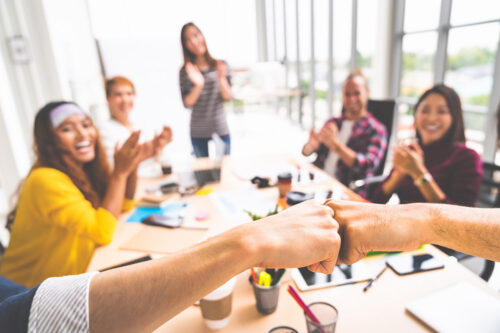 Business partners or men coworkers fist bump in team meeting, mu