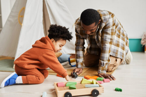 Young Father and Son Playing with Toys