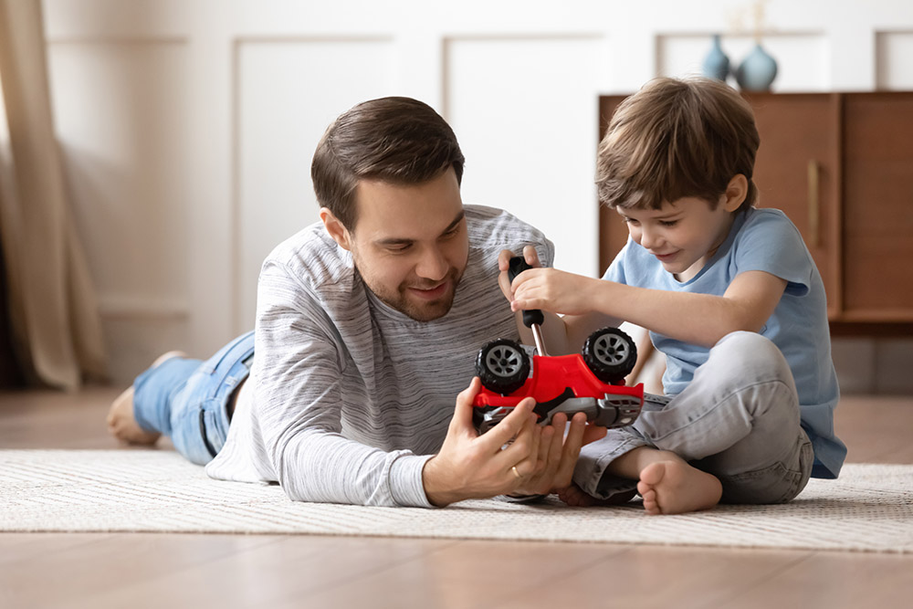 Playful Caucasian father repair car with little son
