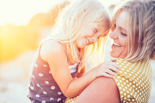 Mom playing with child in sunlight